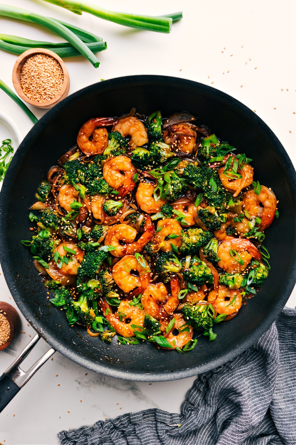 Honey Garlic Shrimp in the skillet with fresh green onions and sesame seeds on top.
