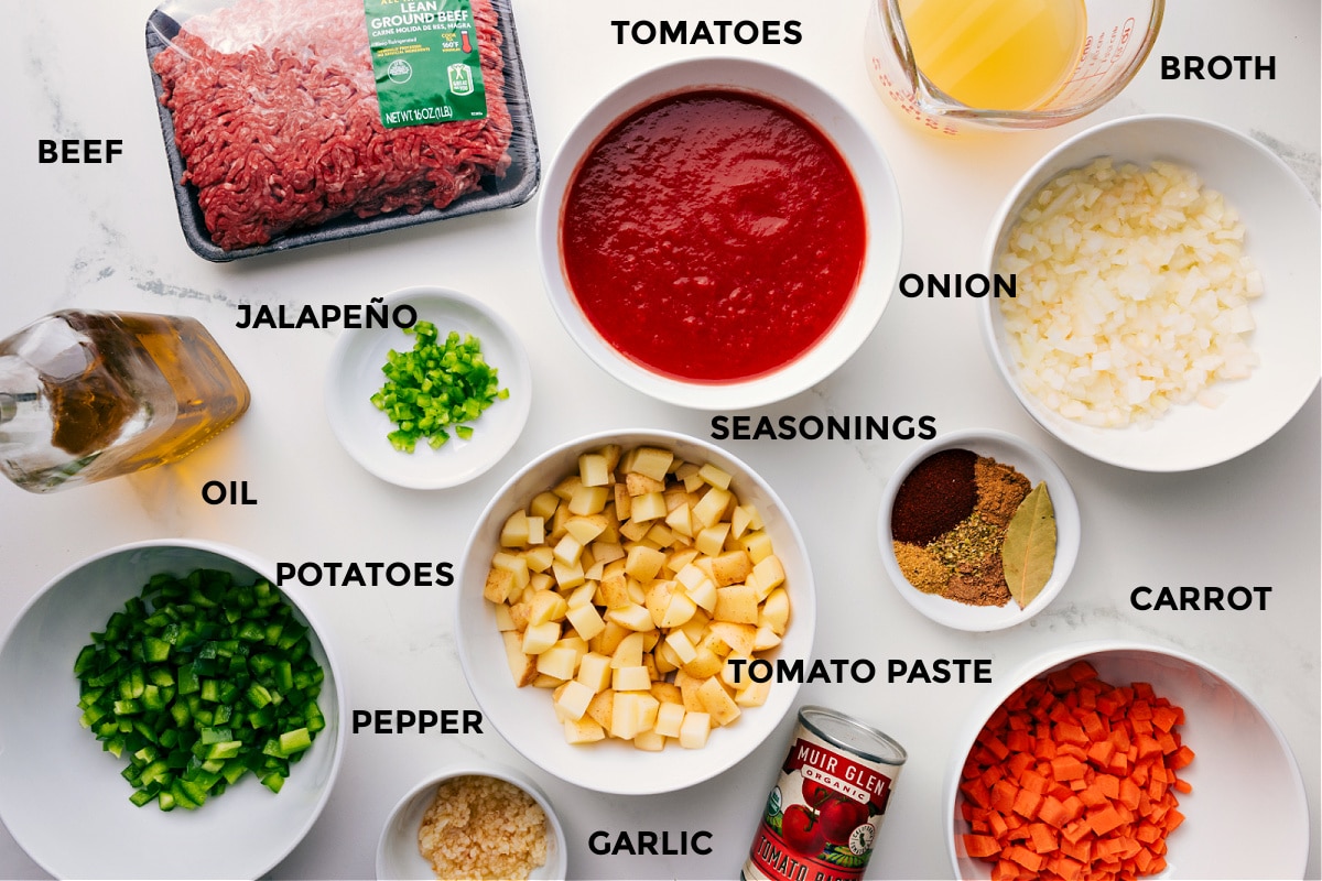 Ingredients In Mexican Picadillo Recipe All the ingredients for this recipe prepped and ready for easy assembly, including the beef, broth, tomatoes, onions, seasonings, carrot, tomato paste, potatoes, jalapeño, oil, pepper, and garlic.