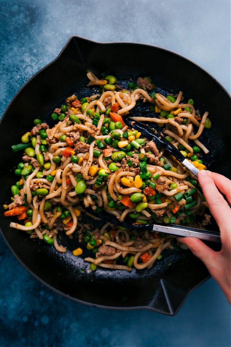 This simple Udon Stir Fry is loaded with flavor and packed with delicious ingredients. Thick and chewy udon noodles, ground meat, and loads of veggies are all tossed in an addictive stir fry sauce! Dinner ready in 30 minutes or less and picky eater approved! Recipe via ChelseasMessyApron #dinner #quick #easy #simple #best #familyfriendly #kidfriendly #vegetables #fresh #udon #stirfry Overhead image of the Udon Stir Fry