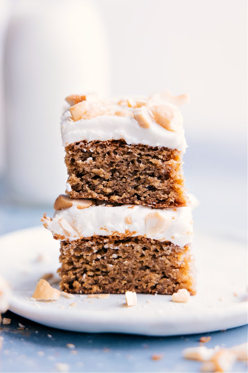 This is my all-time favorite "healthy-ish" cake -- Cashew Cake made with roasted cashews and old-fashioned oats. This cake is dense, moist, and pairs perfectly with the reduced-fat cream cheese frosting -- yum! Recipe via ChelseasMessyApron #dessert #best #quick #easy #simple #treat #healthy #clean #cleaneating #familyfriendly #kidfriendly #cashew #cake Image of two slices of Cashew Cake stacked on top of each other