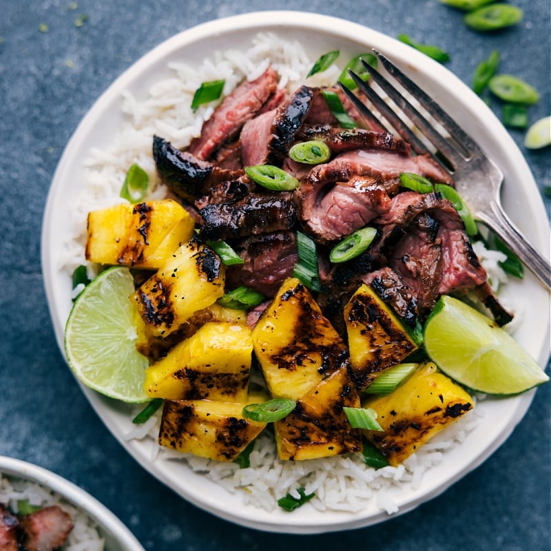 From the coconut-lime rice to the perfectly seasoned steak to the sweet smoky pineapple topping! Recipe via ChelseasMessyApron #dinner #quick #easy #simple #best #fresh #clean #cleaneating #whole30 #keto #lowcarb #pineapple #chicken Overhead image of the dish ready to be enjoyed