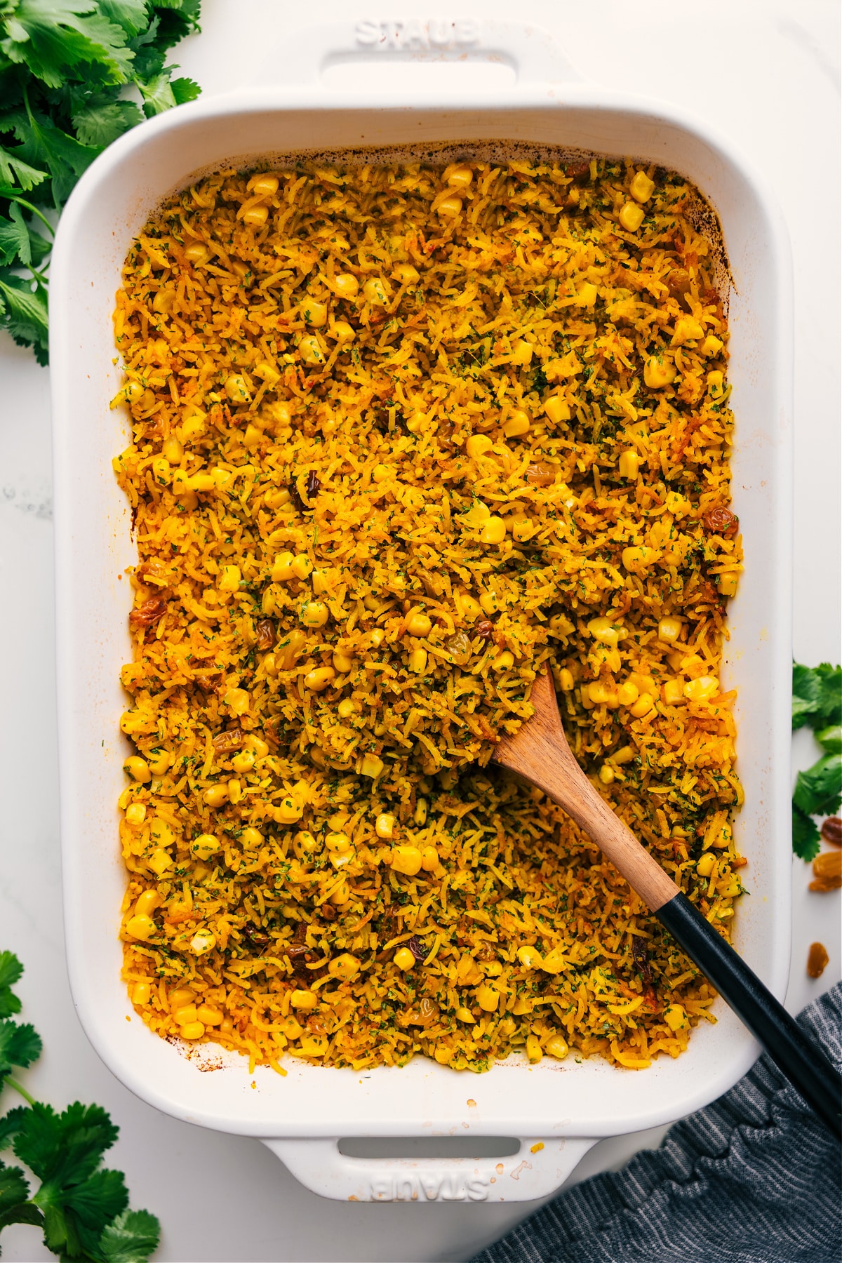 Yellow rice recipe with a large spoonful being scooped from the pan.