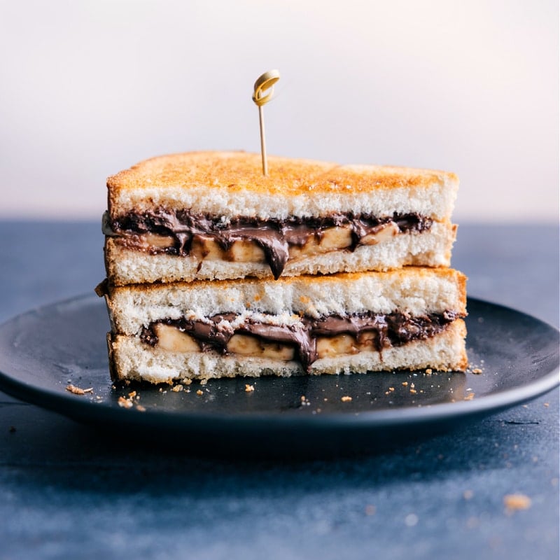 An air-fried peanut butter and jelly is the best! Today we're sharing an Air Fryer Sandwich recipe 4 different ways! These sandwiches are perfect for a meal on the go, quick lunch or snack, or light dinner! Recipe via chelseasmessyarpon.com #dessert #quick #easy #simple #best #afterschoolsnack #airfryer #sandwich Image of the Peanut Butter and Nutella Air Fryer Sandwich