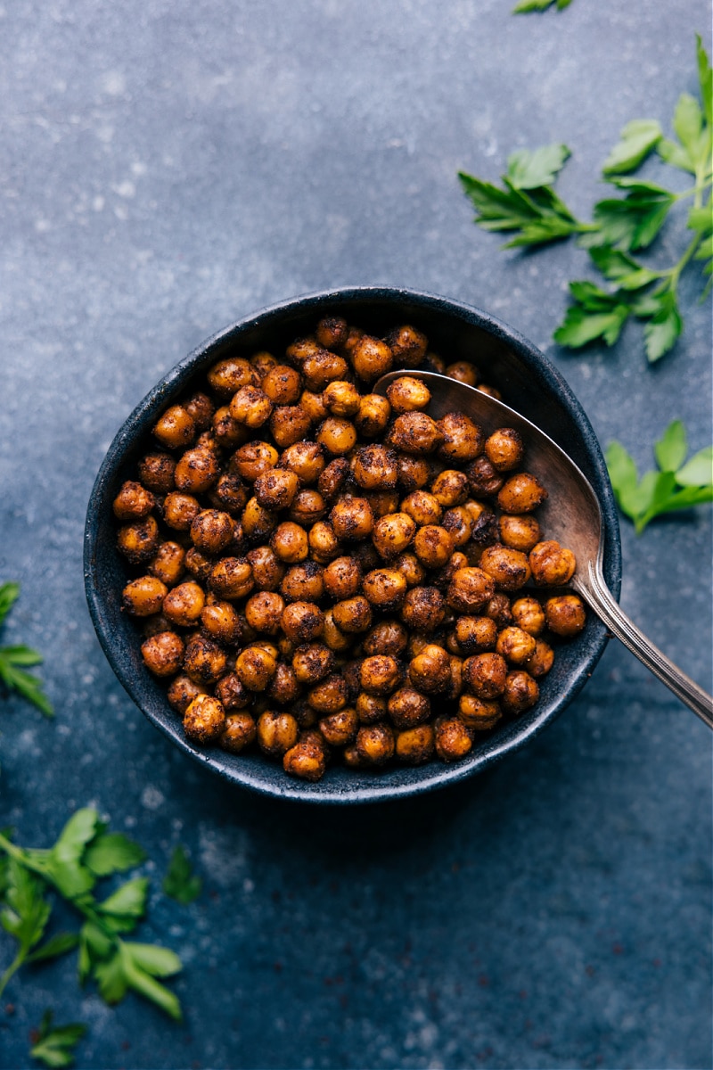These Air Fryer Chickpeas are generously seasoned with a delicious savory flavor! They're quick to prep and crisp up beautifully in the Air Fryer. Recipe via ChelseasMessyApron #sidedish #best #quick #easy #simple #snacks #paleo #glutenfree #dairyfree #familyfriendly #airfryer #chickpeas Overhead image of the Air Fryer Chickpeas in a bowl