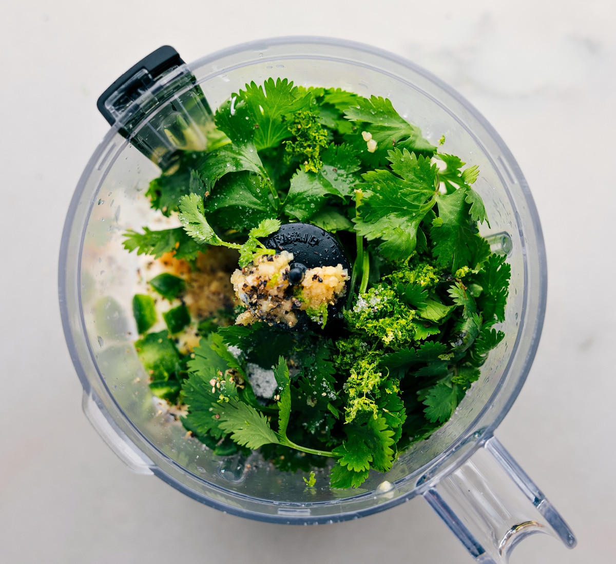 How To Make Cilantro Lime Sauce All the ingredients in the cilantro lime sauce being added to a food processor.