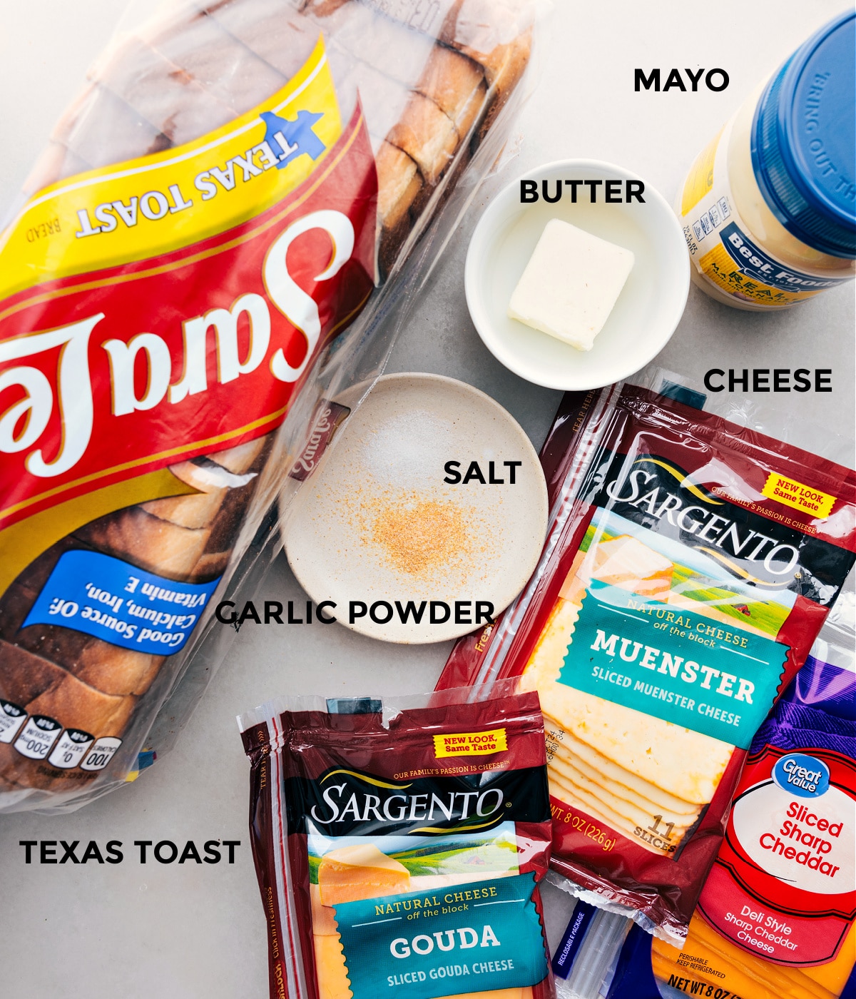 Ingredients In Grilled Cheese All the ingredients in this recipe prepped out for easy assembly including bread, cheddar, muenster, gouda, mayo, butter, and seasonings.