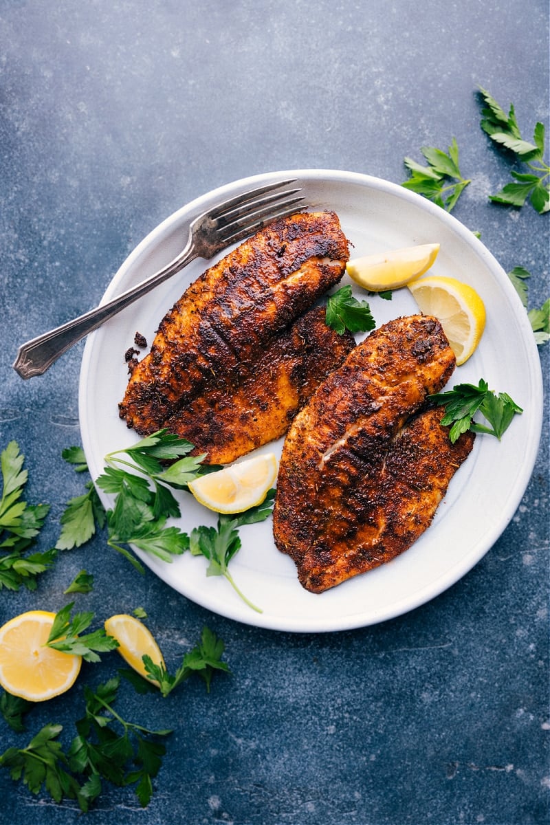 This spice-rubbed Air Fryer Tilapia is one of the easiest, yet tastiest meals to make! This nutritious dish can be prepared and on the table in about 20 minutes or less! Knowing the basics for air frying tilapia is a great resource to have on hand as it can be a springboard for so many other recipes. Plus, we're not just sharing one spice rub, but two -- a Mexican-inspired blend as well as a Cajun-inspired blend! Recipe via chelseasmessyapron #dinner #quick #easy #simple #best #fresh #healthy #airfryer #tilapia Overhead image of Air Fryer Tilapia