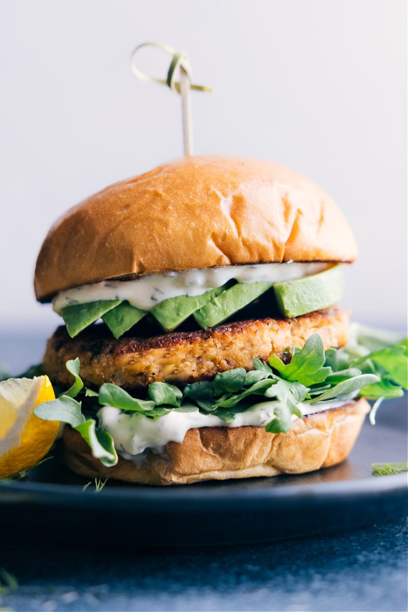 These are our all-time favorite Salmon Burgers complete with a buttered and toasted brioche bun, a succulent and well-seasoned salmon patty, and the best tartar sauce. Add a handful of greens and a ripe avocado to your burger and be ready to have these burgers on permanent dinner rotation! Recipe via ChelseasMessyApron #dinner #quick #easy #simple #familyfriendly #kidfriendly #grilled #healthy #cleaneating #salmon #burger Image of the Salmon Burger on a plate