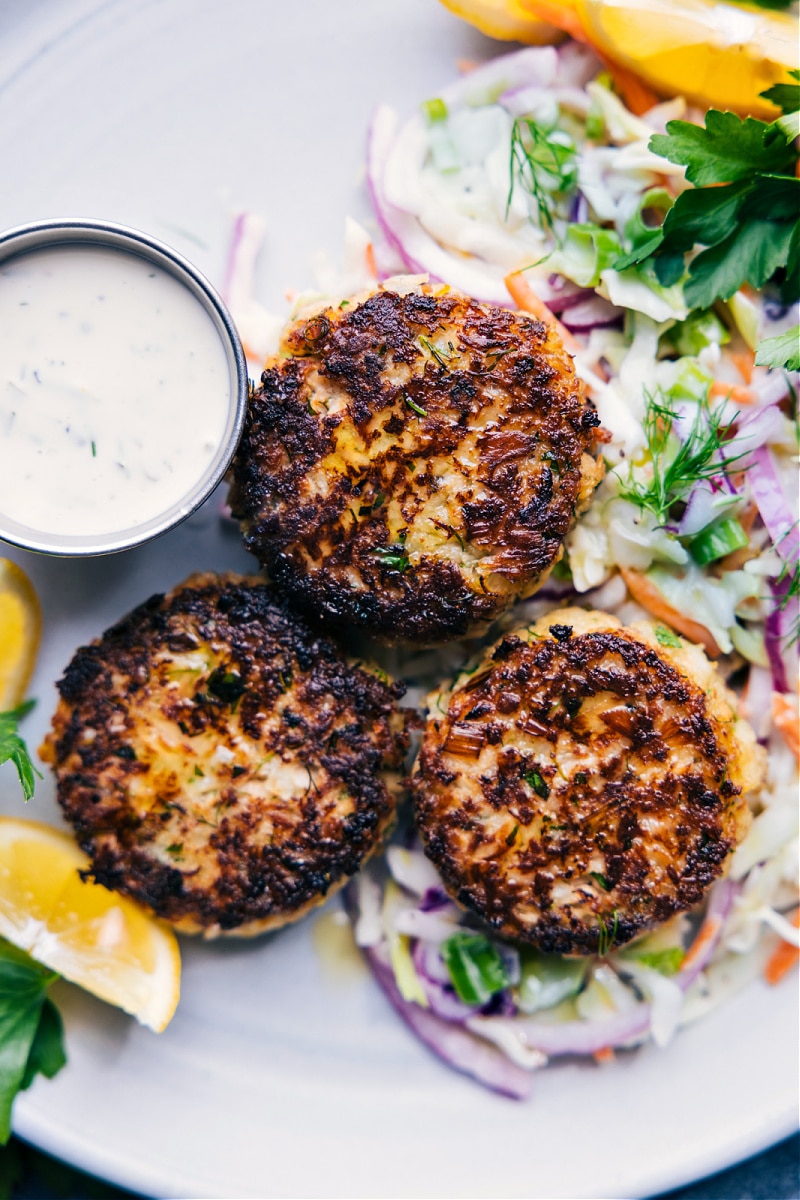 Tuna Patties are packed with flavor and have the best texture -- crisp on the top and bottom with a soft (never dry or hard) interior. These patties are so quick and easy to make (thank you canned tuna!) and sure to be a family favorite! Serve your patties over a quick (2-ingredient) slaw and with a tasty tartar sauce. Recipe via ChelseasMessyApron #dinner #quick #easy #simple #best #fresh #familyfriendly #kidfriendly #tuna #patties Overhead image of Tuna Patties
