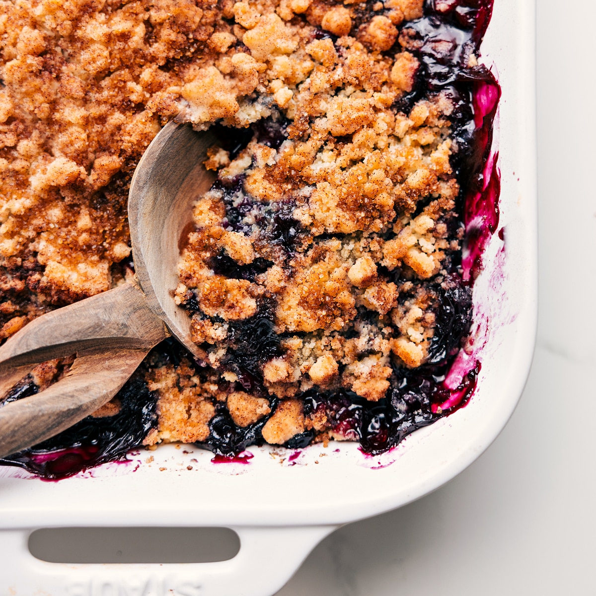 My Favorite Blueberry Cobbler Recipe Freshly baked blueberry cobbler with a spoonful being served from the dish.