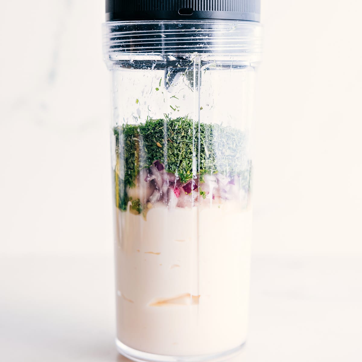 Blend Together Ingredients For Green Goddess Dressing All the ingredients for the green goddess dressing are added to a blender jar for blending.