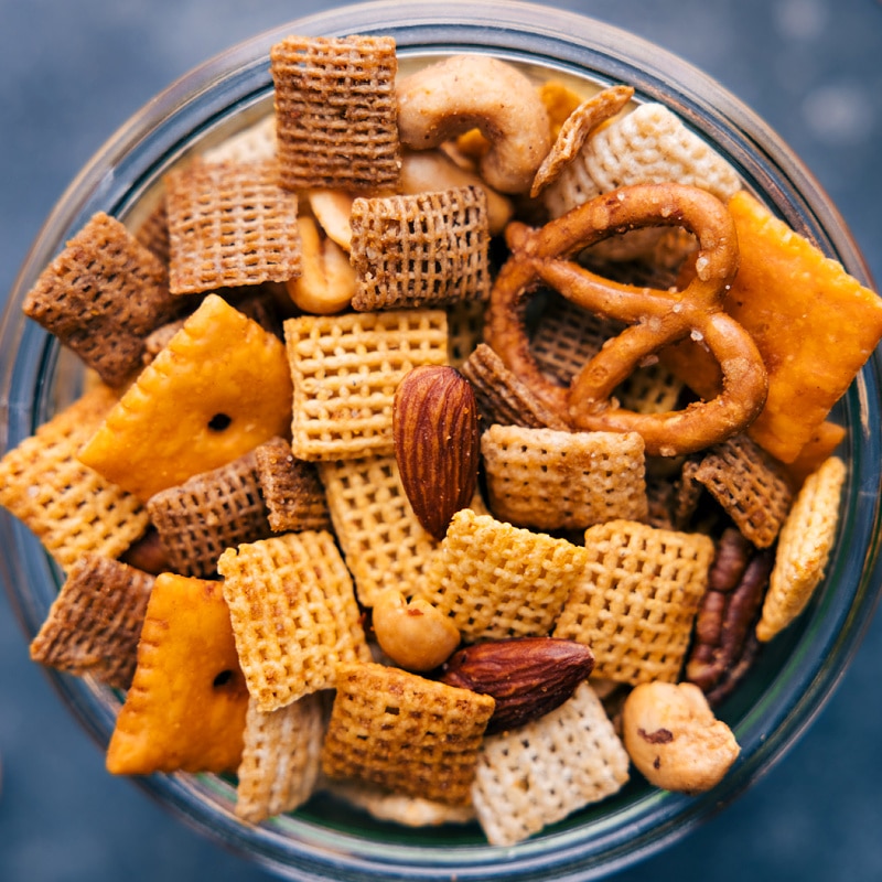This Chex Mix Recipe is loaded with crispy cereal, pretzels, cheese crackers, and nuts. The seasoned butter pulls everything together into a mix that is nothing short of addicting! Recipe via ChelseasMessyApron.com #snackmix #chexmix #chex #snack #cereal Close-up view of Chex Mix