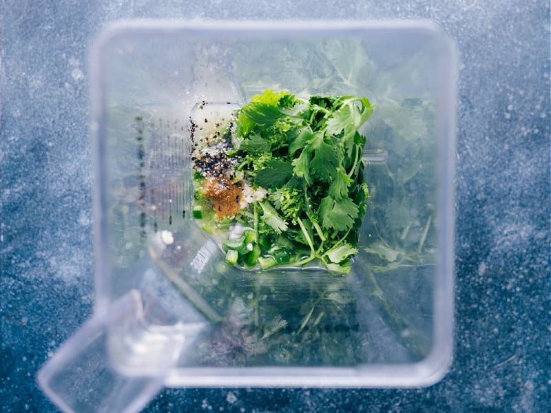 This bright and vibrant Cilantro Lime Dressing owes its flavor to fresh lime juice and citrusy cilantro. Plus it's easy to prepare -- simply throw everything into a blender and let it whirl! This naturally vegan, dairy-free, and gluten-free Cilantro Lime Dressing checks all the nutrition boxes. Recipe via ChelseasMessyApron.com #cilantrolime #cilantro #lime #citrusy #glutenfree #vegan #dairyfree #salads overhead view of ingredients in the blender