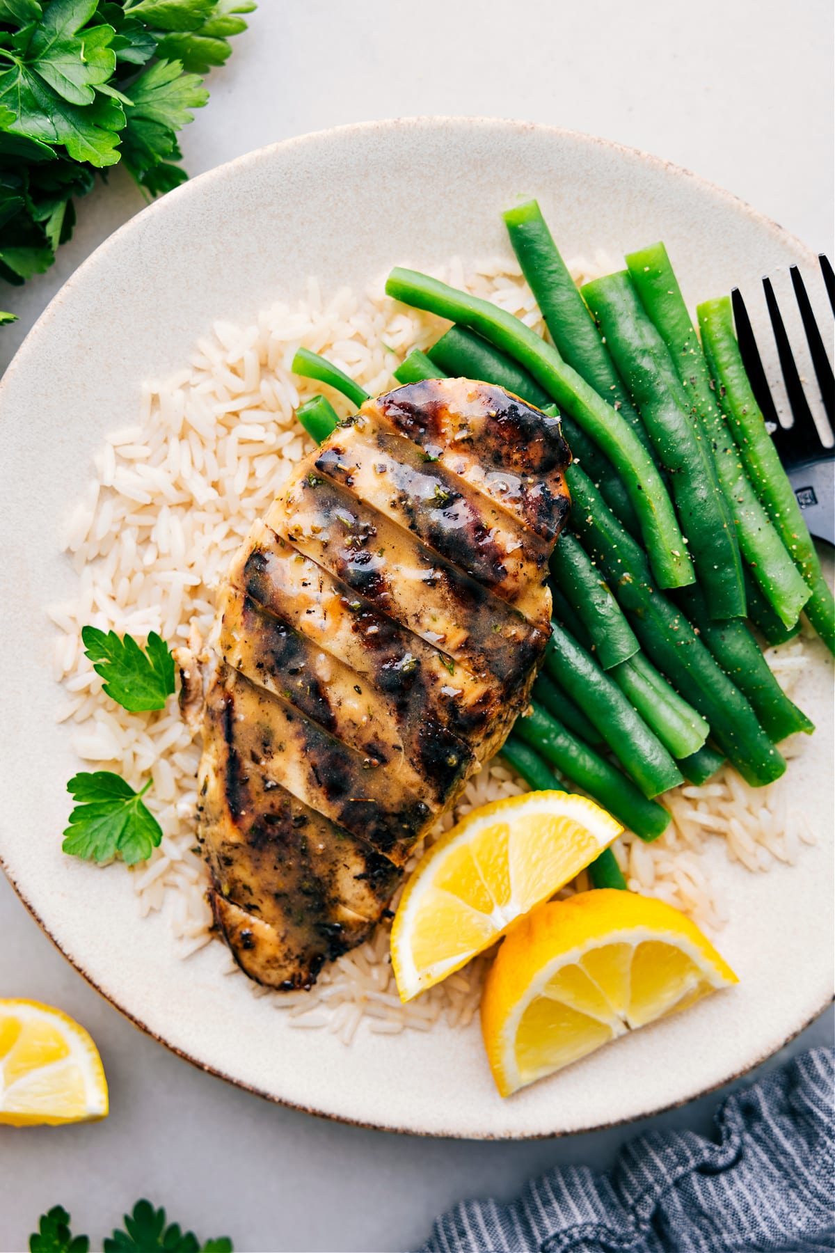 Italian Chicken Marinade Recipe Italian Chicken Marinade recipe on a plate over a bed of rice with green beans.