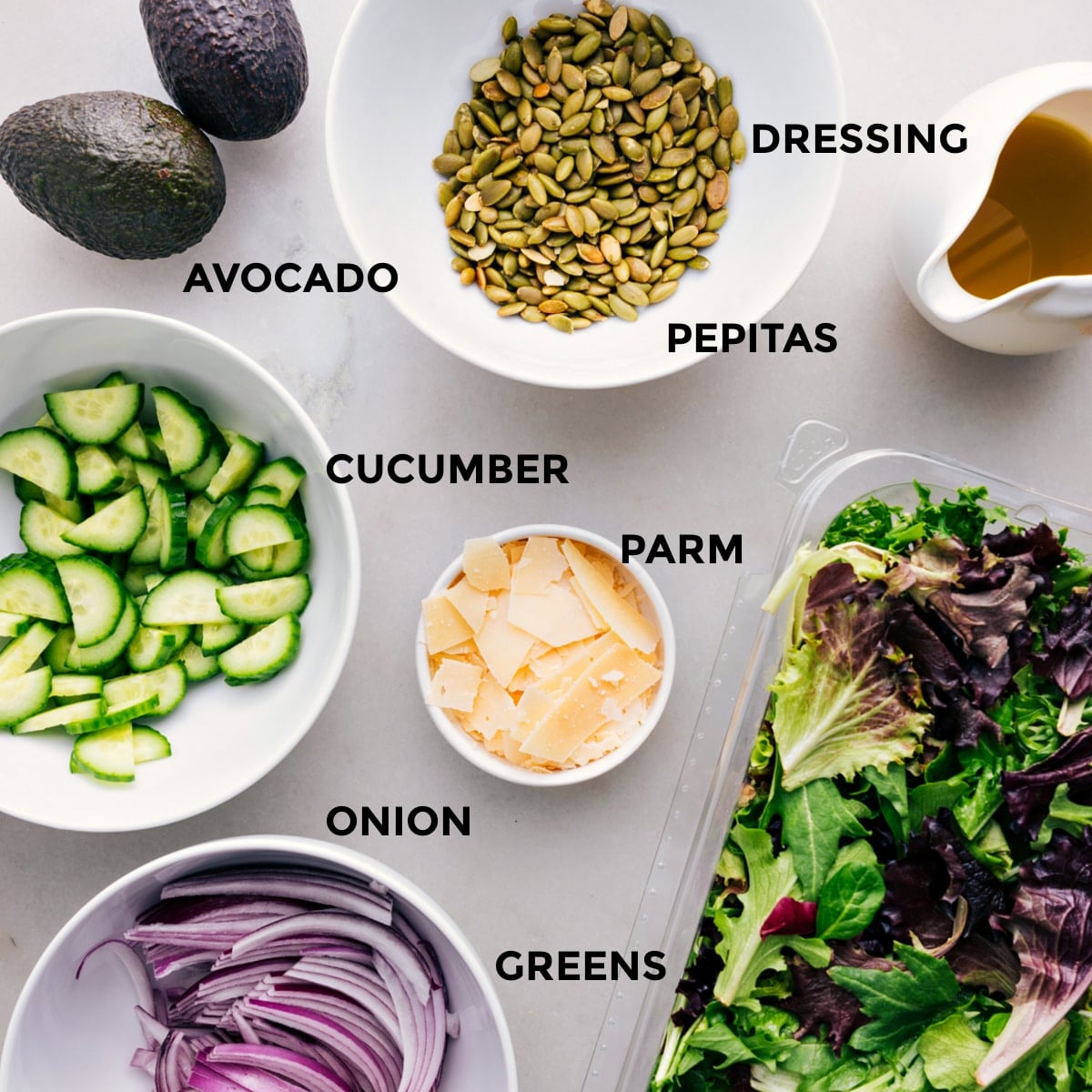 Ingredients In This Everyday Salad Recipe All the ingredients for this recipe—dressing, pepitas, avocado, cucumber, parm, greens, and onion—prepped and ready for easy assembly.