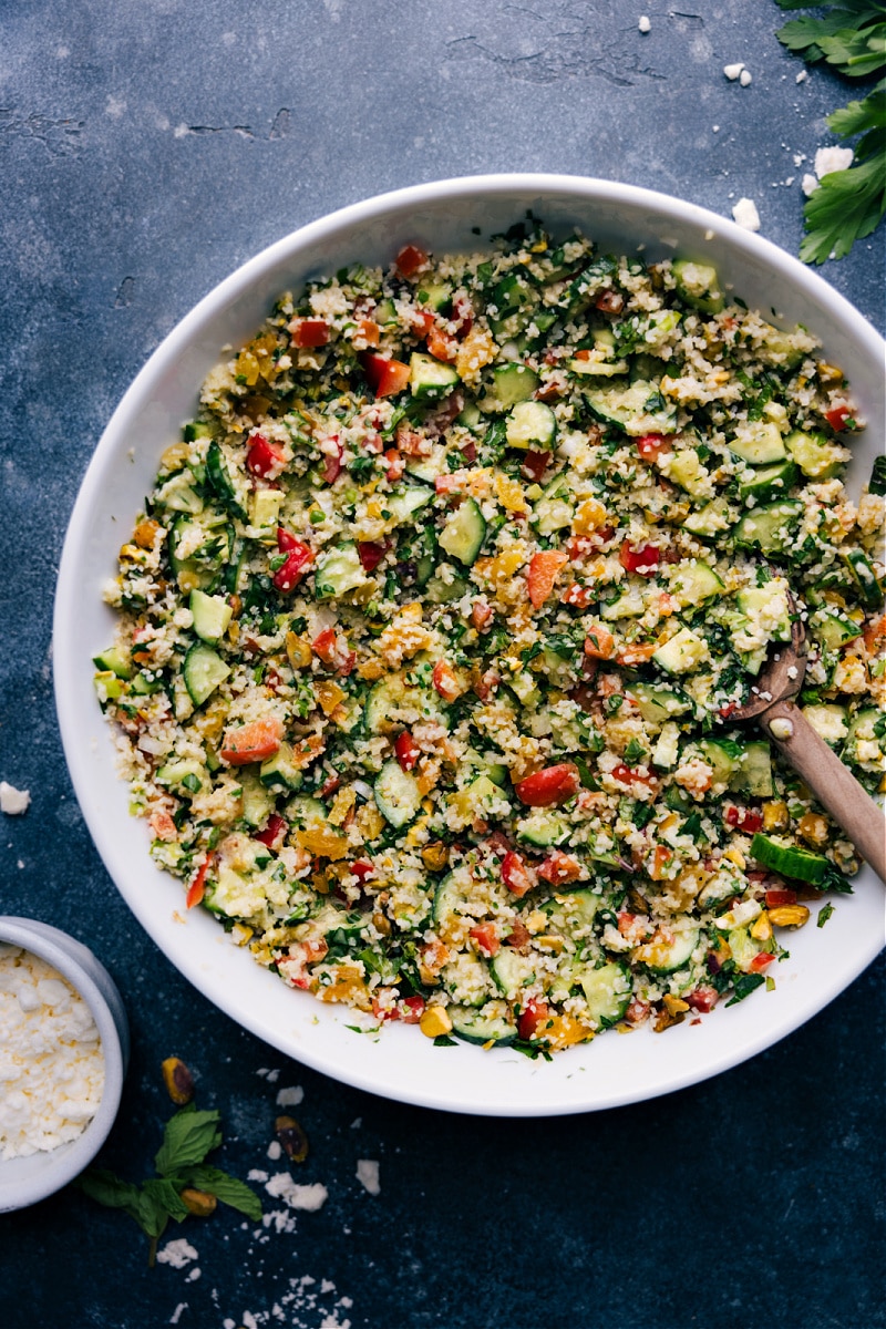 This Bulgur Salad is a powerhouse recipe -- packed with so much texture and flavor! Cooked and cooled bulgur wheat gets tossed with crisp cucumbers, sweet bell pepper, dried apricots, salty pistachios, and a vibrant herb blend. The fresh lemon-mint dressing finished everything off beautifully! Recipe via ChelseasMessyApron.com #tabouli #bulgur #wheat #wholegrain #salad #lemony #minty #vegetarian Overhead view of Bulgur Salad in a bowl