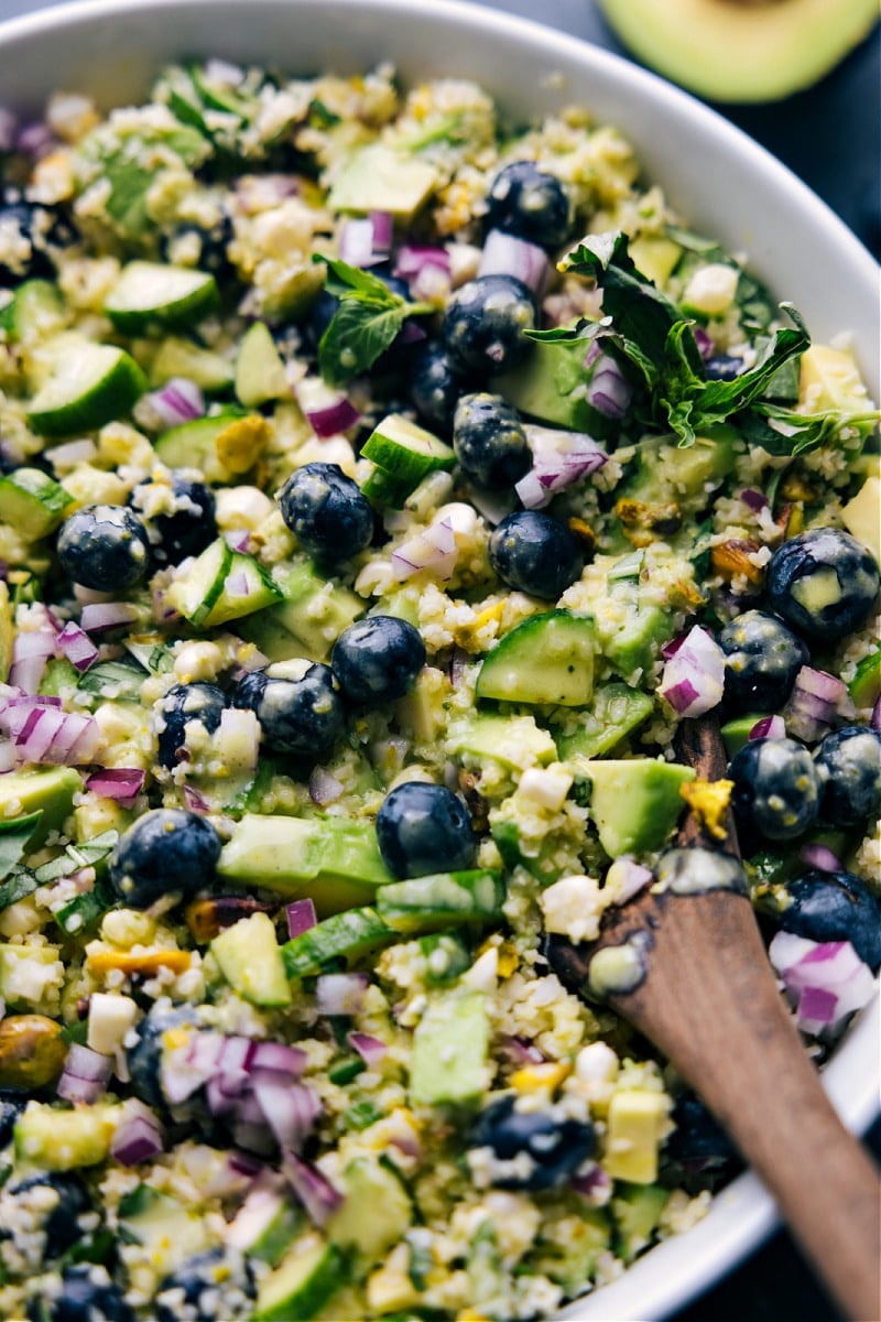 This is our favorite Blueberry Corn Salad! Crisp corn, sweet blueberries, creamy avocado, crunchy pistachios, salty feta, and the BEST lemon-basil vinaigrette combine to create an unforgettable meal! Recipe via chelseasmessyapron #dinner #quick #easy #simple #lunch #best #familyfriendly #kidfriendly #blueberry #corn #salad Up-close overhead image of Blueberry Corn Salad in a bowl ready to be enjoyed