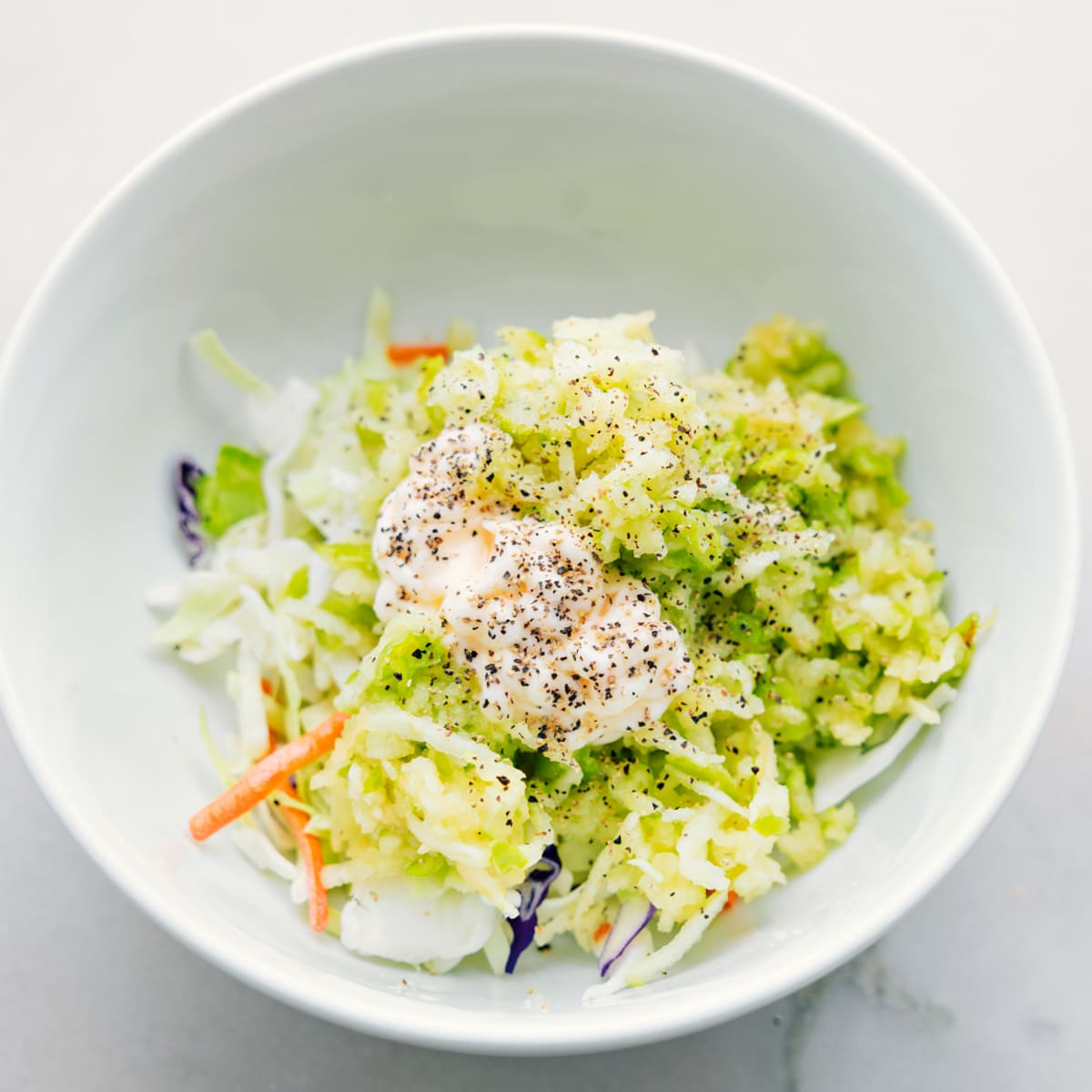 Coleslaw Filling For Healthy Turkey Wraps The coleslaw mix ingredients being added to a bowl for these healthy turkey wraps.