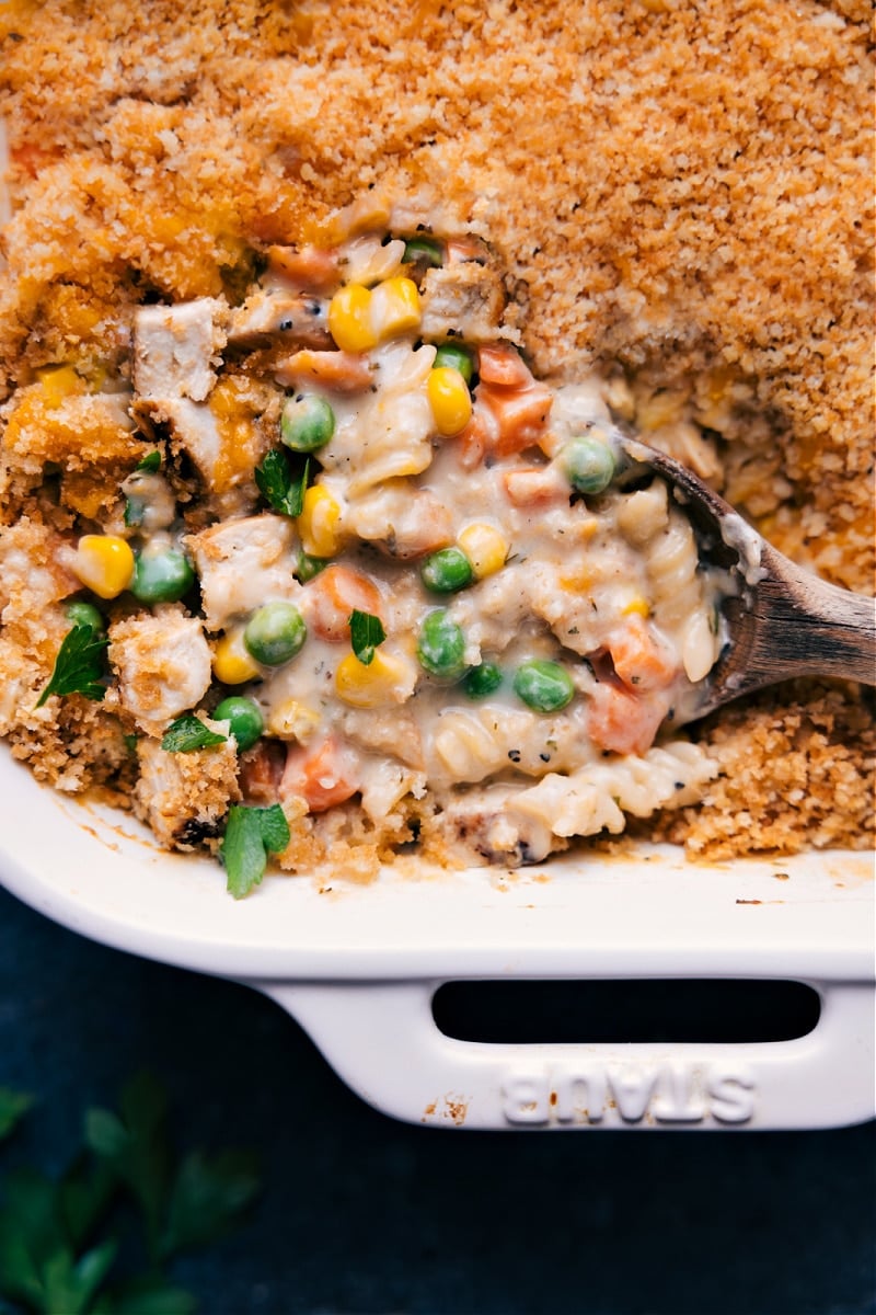 Chicken Noodle Casserole channels all the flavors you know and love from chicken noodle soup into a creamy, cheesy casserole dish the whole family will love! This is the absolute best-ever version of the popular casserole--it's got loads of veggies, tender chicken, a cheesy cream sauce, and a crunchy topping. Recipe via chelseasmessyapron #dinner #quick #easy #simple #best #familyfriendly #kidfriendly #comfortfood #chickennoodle #casserole Up close overhead image of the Chicken Noodle Casserole ready to be enjoyed