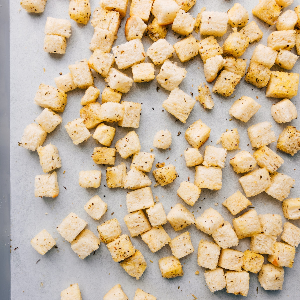 How To Make Homemade Croutons Homemade croutons on a sheet pan, coated in oil and seasonings, ready to be roasted.