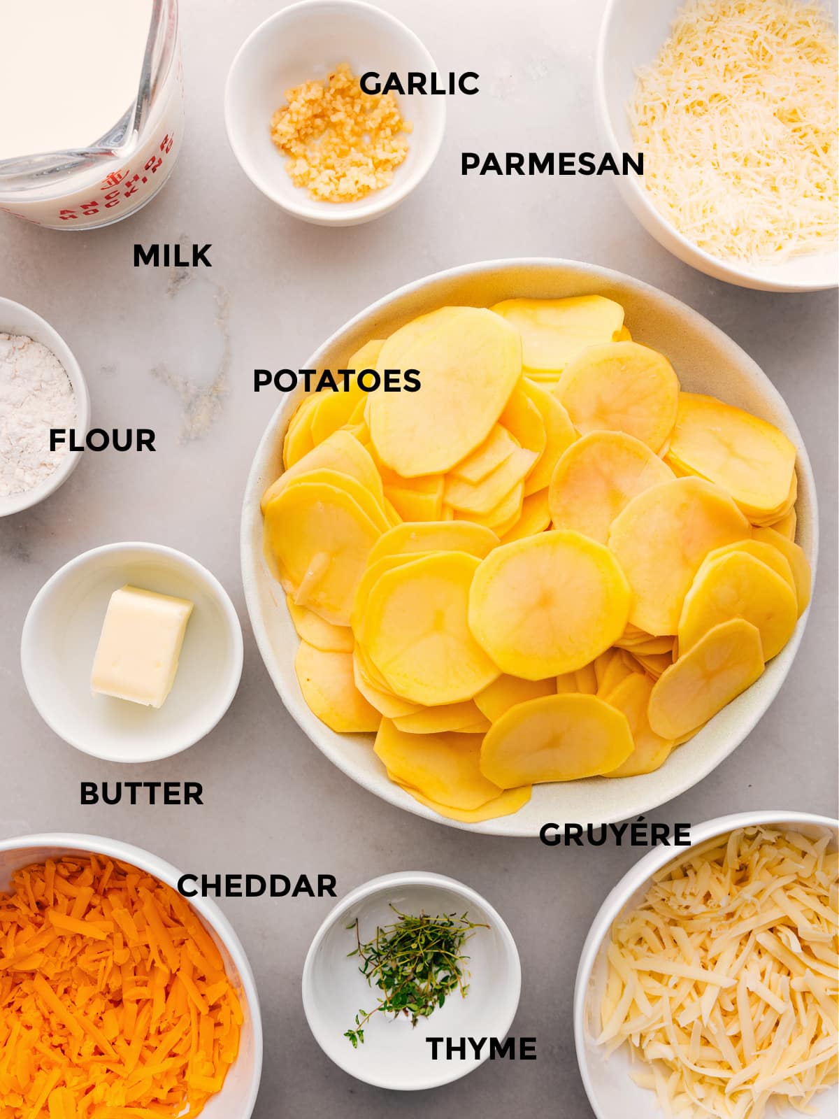 Ingredients In Au Gratin Potatoes The ingredients for this recipe—potatoes, flour, butter, thyme, cheese, milk, and garlic—are prepped and ready for easy assembly.
