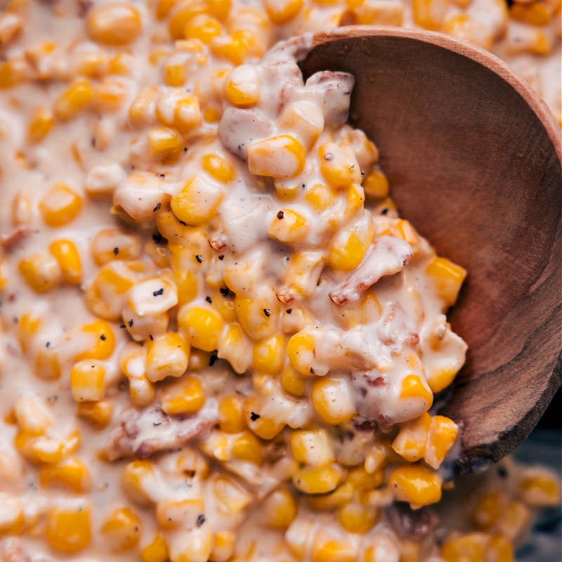 Everyone's favorite Creamed Corn recipe complete with loads of sweet corn, smoky bacon, and the best savory Parmesan cream sauce. Recipe via chelseasmessyapron #sidedish #thanksgiving #best #familyfriendly #comfortfood #creamy #creamed #corn U- close overhead image of Creamed Corn ready to be enjoyed