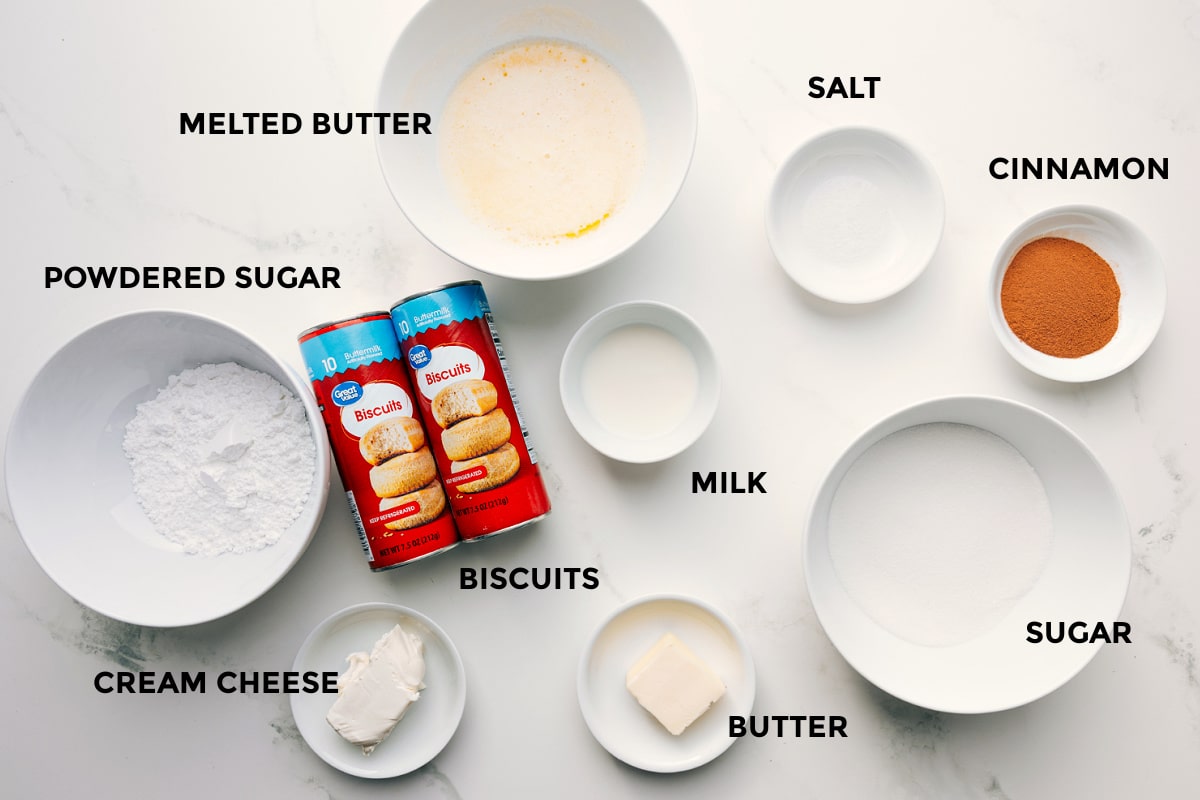 Ingredients In Cinnamon Roll Cake Recipe All the ingredients in this recipe prepped out for easy assembly including the powdered sugar, cream cheese, melted butter, biscuits, milk, butter, salt, cinnamon, and sugar.