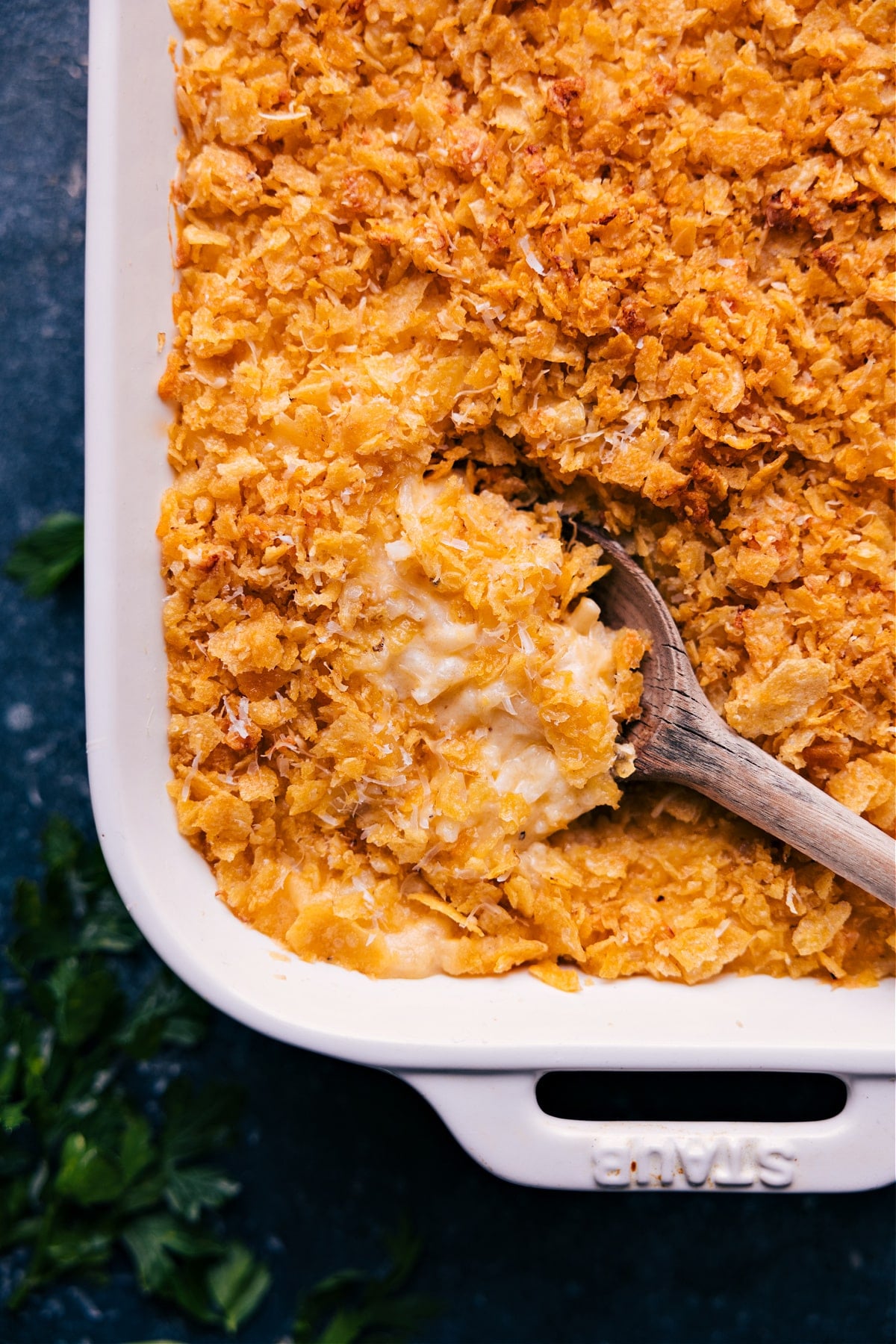 Cheesy And Delicious Funeral Potatoes A spoonful of Funeral Potatoes scooped from the casserole dish.