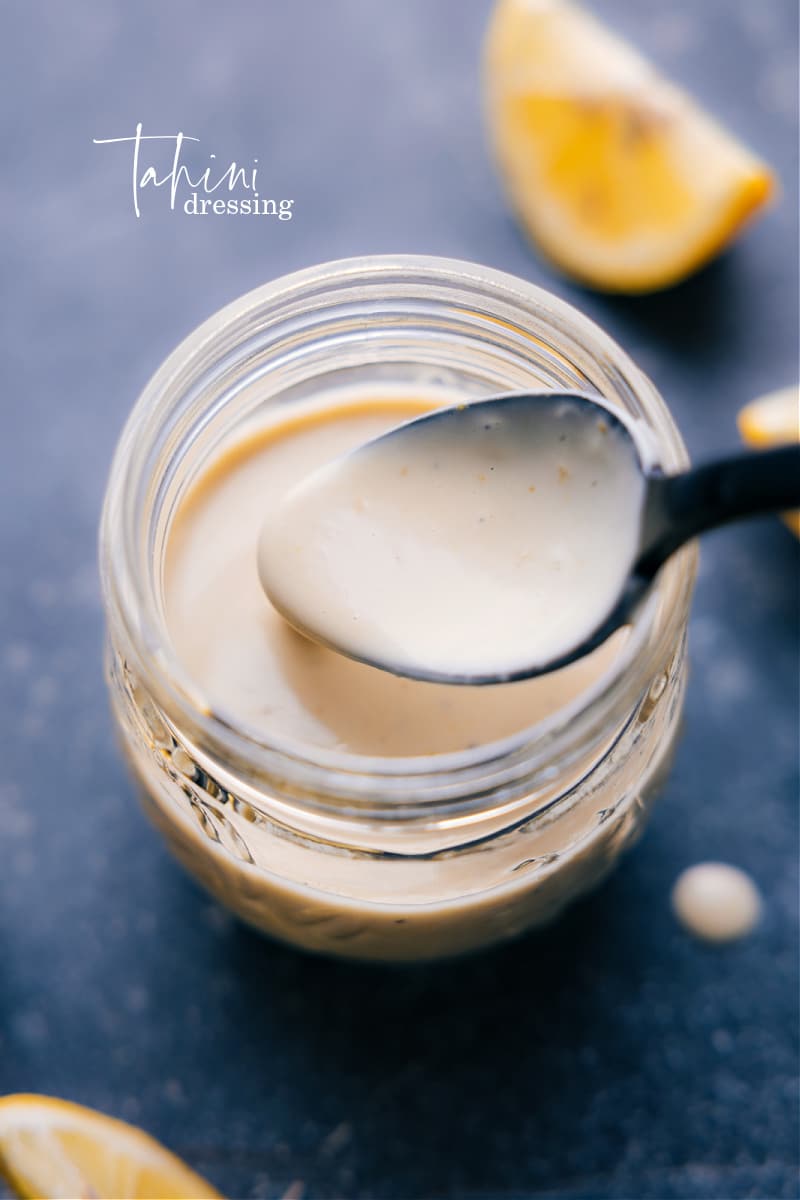 This Tahini Dressing is luxuriously thick and creamy without any mayo or cream! It's delightfully flavored with a hint of lemon and touch of honey. Drizzle this dressing on your favorite salad. Recipe via chelseasmessyapron #salad #saladdressing #tahini #dressing Overhead image of Tahini Dressing