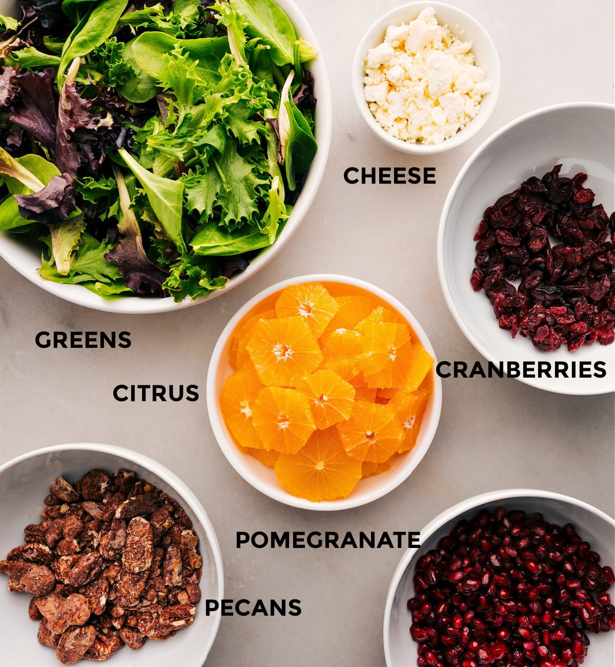 Ingredients In The Best Winter Salad This recipe is prepped for easy assembly with greens, cheese, cranberries, citrus, pomegranate, and pecans.
