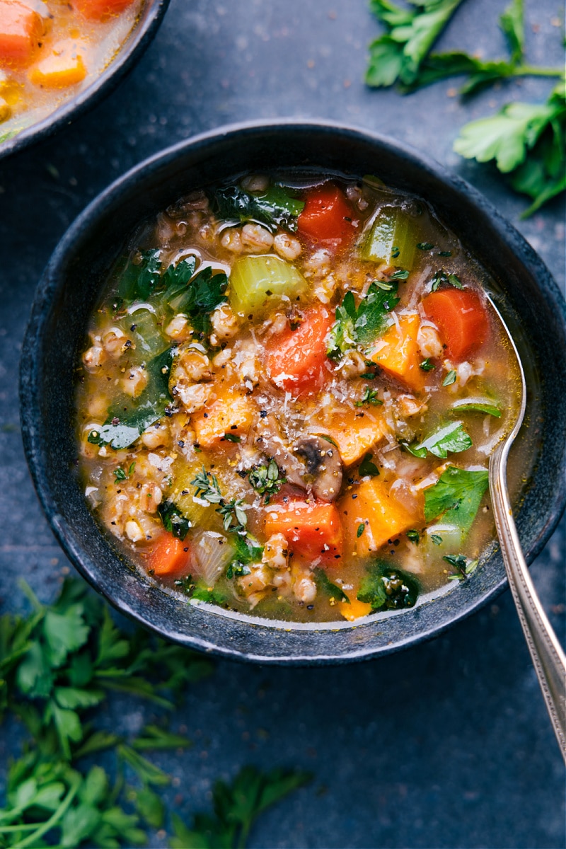 This hearty and nutritious one-pot Farro Soup is loaded up with tons of veggies, a rich seasoned broth, and plenty of farro. It's incredibly delicious and you'll feel great eating it! Top your bowl with some fresh herbs and a sprinkle of Parmesan cheese-- and then grab some crusty bread for dunking! Recipe via ChelseasMessyApron.com #farro #soup #wholegrain #veggies #heartysoup #vegetarian #vegan Farro Soup served up in a bowl to be enjoyed.