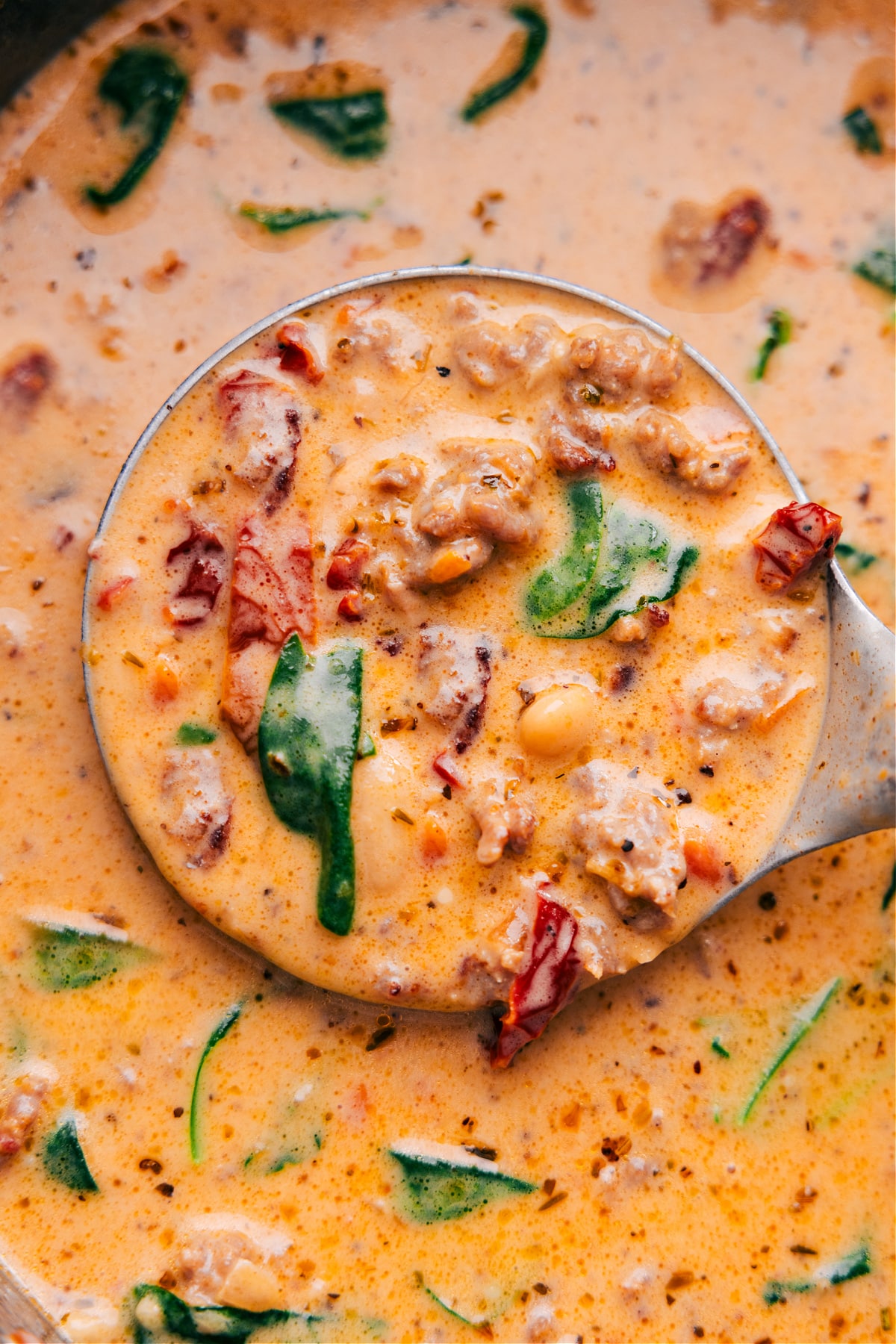 Scoop Out Some Tuscan Soup And Enjoy The best Tuscan soup in a pot, scooped up with a ladle, showing all the delicious ingredients.