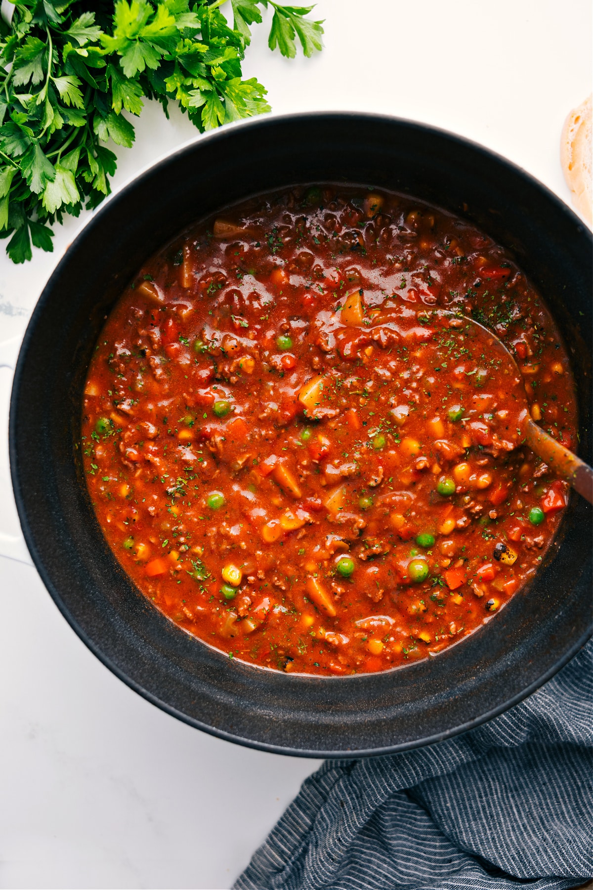 Vegetable Beef Soup Recipe in the pot with a ladle full coming out.