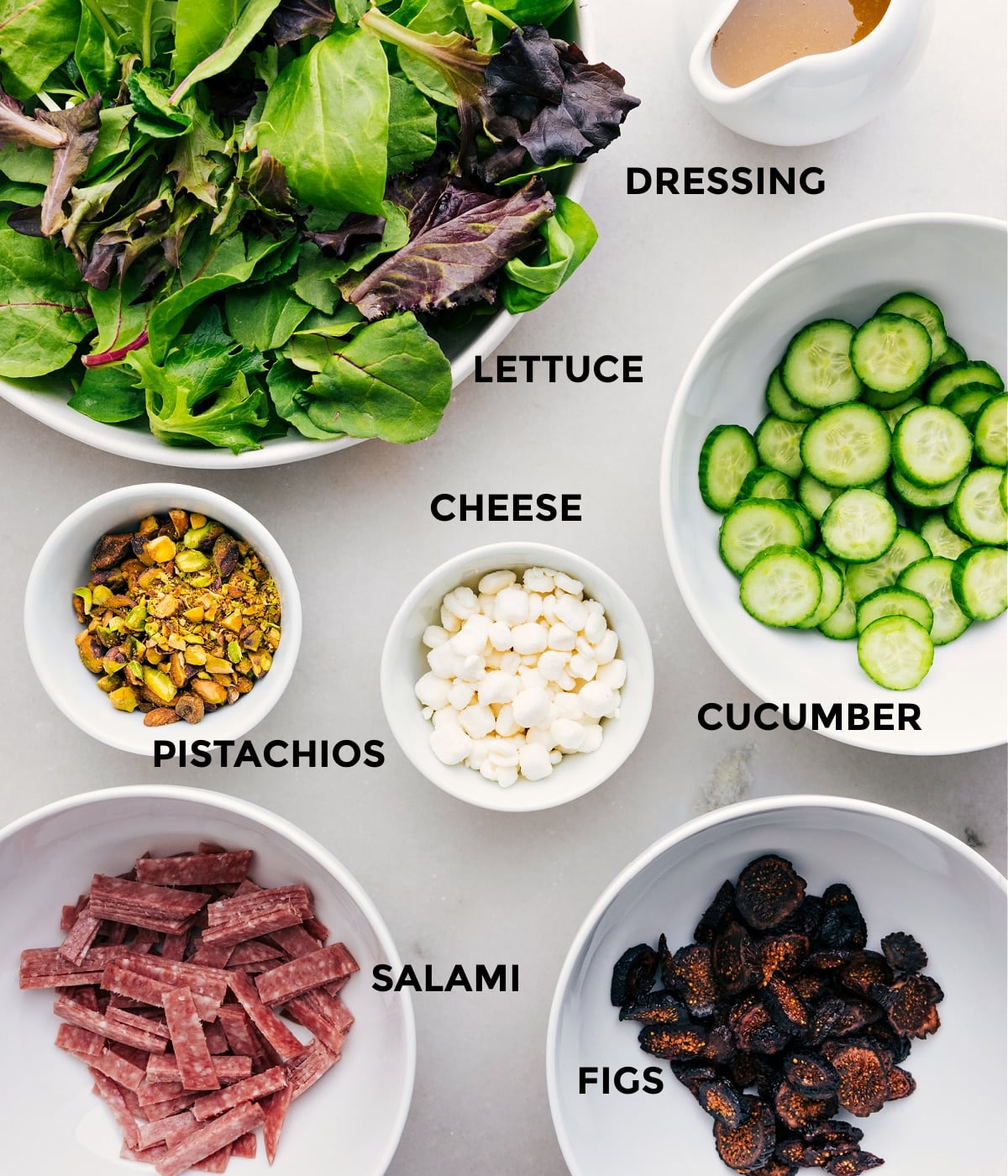 Ingredients In Arugula Salad Recipe All the ingredients in this recipeโgreens, dressing, cucumbers, cheese, pistachios, salami, and figsโare prepped for easy assembly.
