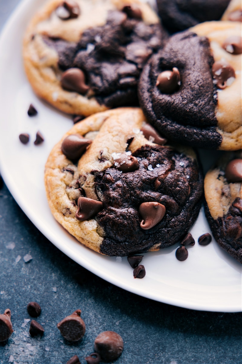 Get ready to experience the ultimate cookie mashup! Brookies - a mouthwatering combination of rich, fudgy brownie-like chocolate cookies and classic chocolate chip cookies. These little delights are a match made in cookie heaven, offering the perfect balance of chocolatey goodness with sweet and buttery flavors. Recipe via chelseasmessyapron #dessert #best #quick #easy #simple #familyfriendly #treat #chocolatechipcookies #cookies #brownies #brookies Brookies on a plate.