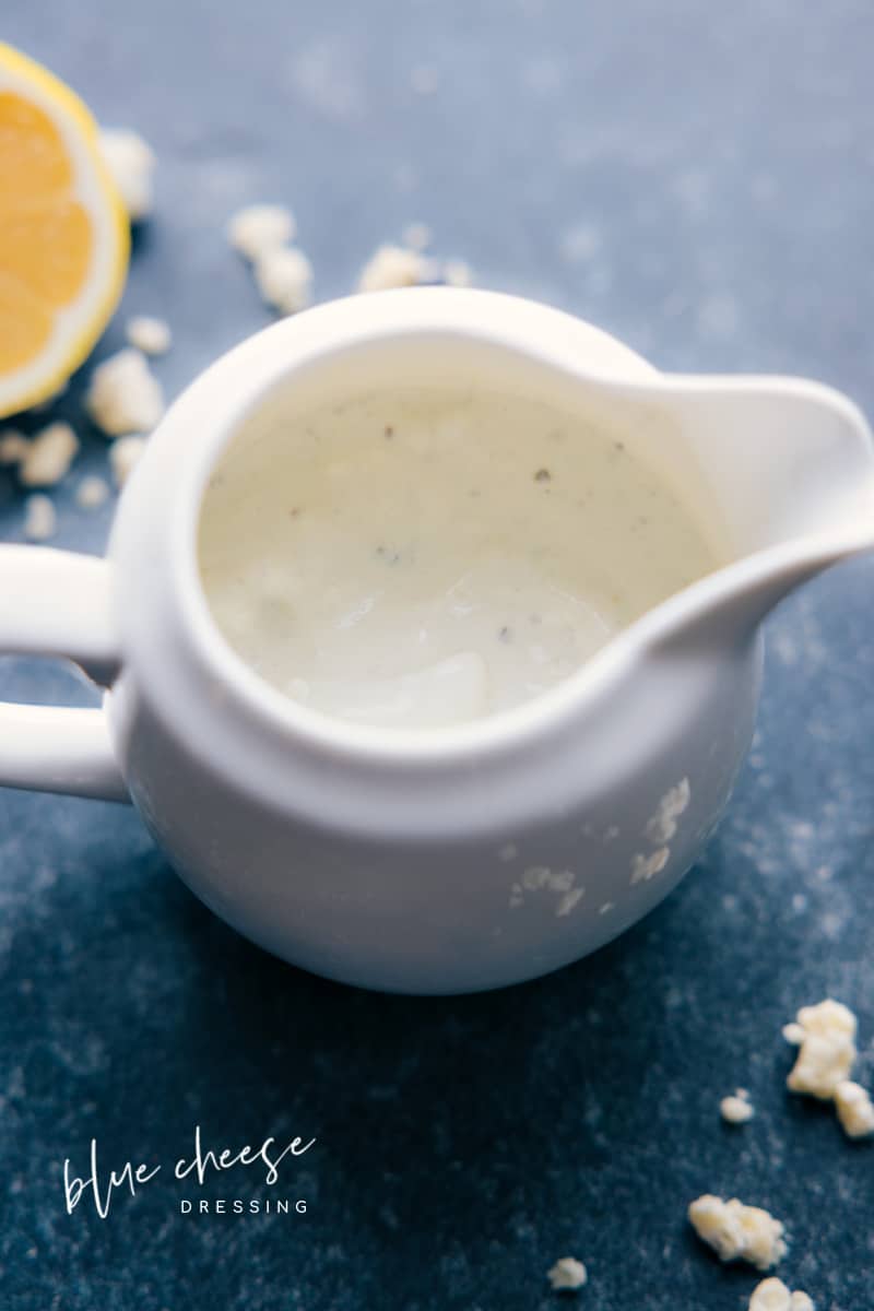 This Blue Cheese Dressing recipe is creamy, tangy, and downright delicious! Made with crumbled blue cheese, buttermilk, mayonnaise, sour cream, white wine vinegar, and fresh lemon, this dressing is the perfect blend of flavor and texture. Whether you prefer a smooth or chunky texture, this dressing is versatile and easy to make. So jazz up your lunchtime salad or add a touch of excitement to your dinner party spread, because this blue cheese dressing is the perfect addition to any meal! Recipe via chelseasmessyapron #best #quick #easy #simple #saladdressing #bluecheese #dressing Overhead image of Blue Cheese Dressing