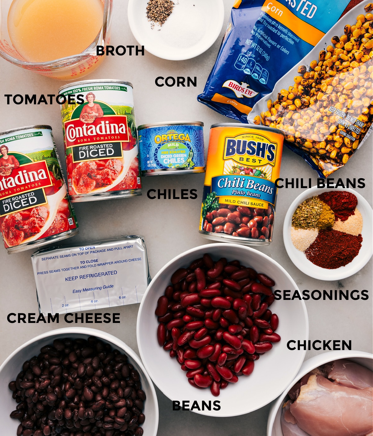 Ingredients In Chicken Taco Chili Recipe Ingredients like broth, seasonings, corn, beans, tomatoes, chiles, cream cheese, and meat prepped and ready for easy assembly.