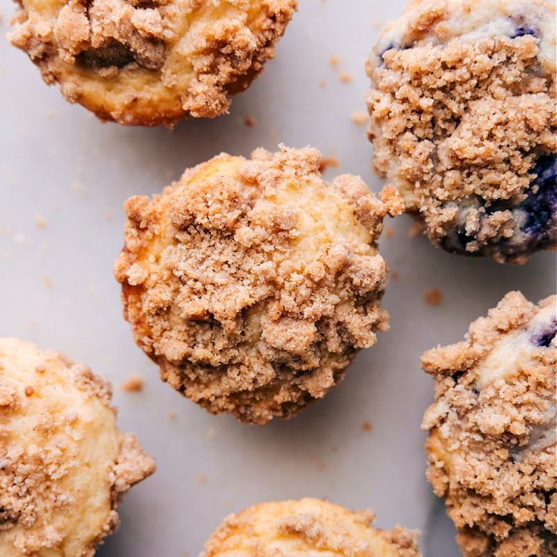 There are few things that can elevate a simple dessert to the next level quite like a crunchy, sweet, and buttery streusel topping. Recipe via chelseasmessyapron #guides #muffins #toppings #best #quick #easy #simple #howtomake #streusel Overhead image of muffins with streusel on top ready to be enjoyed