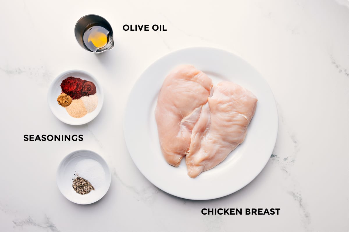 Ingredients In Baked Chicken Breast Ingredients in this recipe prepped out for easy assembly including the olive oil, seasonings, and chicken.