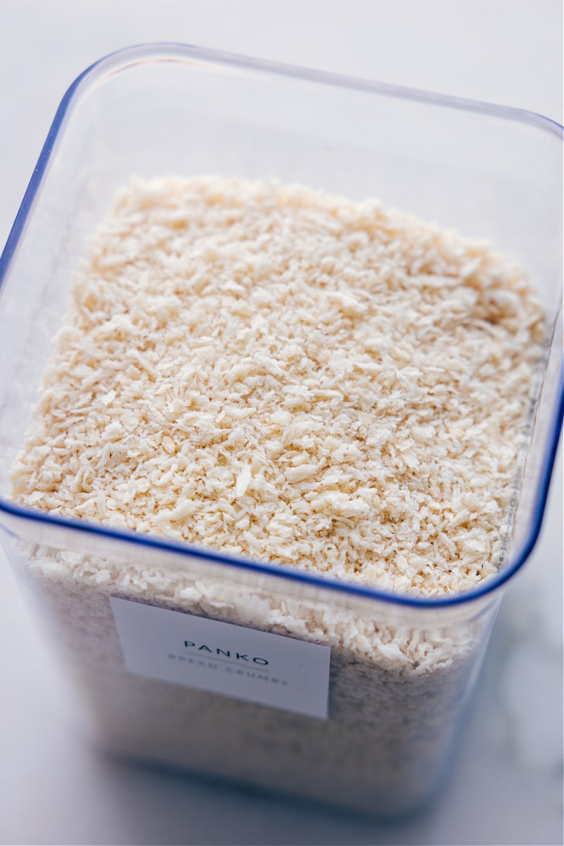 Everything you've always wanted to know about panko! If youโve never tried these extra-crispy bread crumbs, read on to see why theyโre a cookโs best friend! Guide via ChelseasMessyApron.com #panko #userguide #guide #breadcrumbs #Japanese #bread #crispy Overhead view of a container of the ingredient