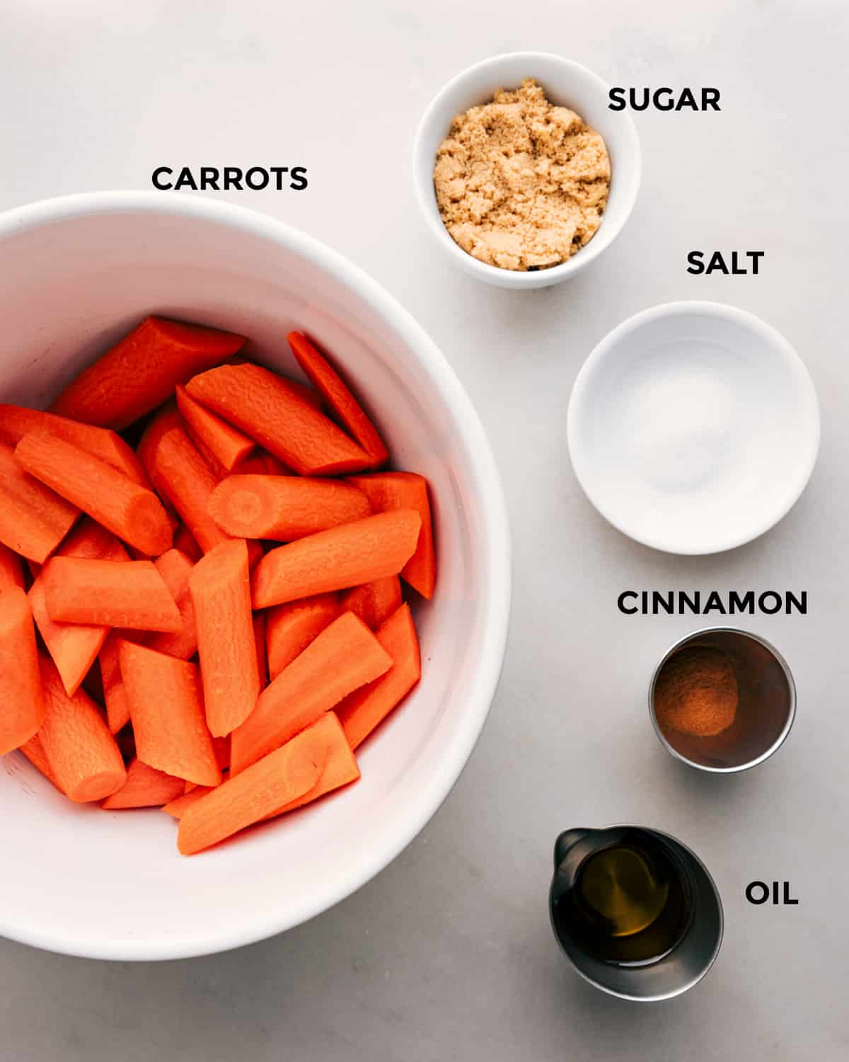 These Brown Sugar Roasted Carrots are a delicious side dish that is sure to be a crowd-pleaser and make the perfect accompaniment to any meal. Recipe via chelseasmessyapron #sidedish #best #quick #easy #simple #familyfriendly #kidfriendly #easter #eastersidedish #easterdinner #brownsugar #roastedcarrots Ingredients in this recipe prepped out for easy assembly including sugar, salt, cinnamon, and carrots.
