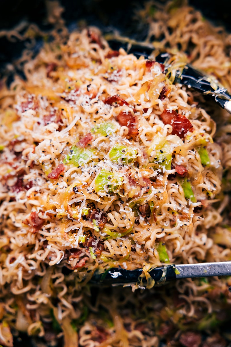If you're looking for a new and delicious way to jazz up your ramen noodles, then you're in for a treat with this Fried Cabbage Ramen recipe! With the addition of smoky bacon, savory onions, and salty parmesan cheese, these noodles are bursting with flavor. This jazzed-up ramen will quickly become a new favorite in your recipe collection! Recipe via chelseasmessyapron #dinner #quick #easy #simple #noodles #asian #stirfry #fried #cabbage #ramen Overhead image of the Fried Cabbage Ramen