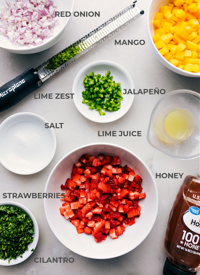 Ingredients In Strawberry Mango Salsa All the ingredients for strawberry mango salsa prepped and ready to go, including chopped onion, diced mango, minced jalapeรฑo, lime juice, sliced strawberries, honey, salt, and lime zest.