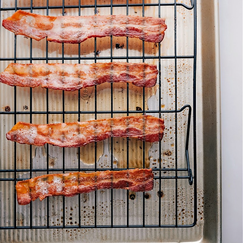 Bacon is one of the most beloved foods of all time. Itโs crispy, savory, and deliciously salty, and can be served in a variety of ways. Today, weโll provide you with a step-by-step guide on How To Bake Bacon to perfection! Recipe via chelseasmessyapron #sidedish #breakfast #best #quick #easy #simple #brunch #onepan #howtobake #bacon Process shots of how to bake bacon-- images of the bacon fresh out of the oven