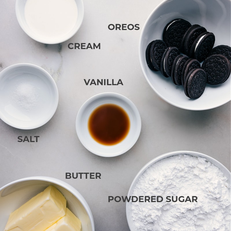 Ingredients In Cookies And Cream Frosting Ingredients in this recipe prepped out for easy assembly including the cream, Oreos, salt, vanilla, powdered sugar, and butter.