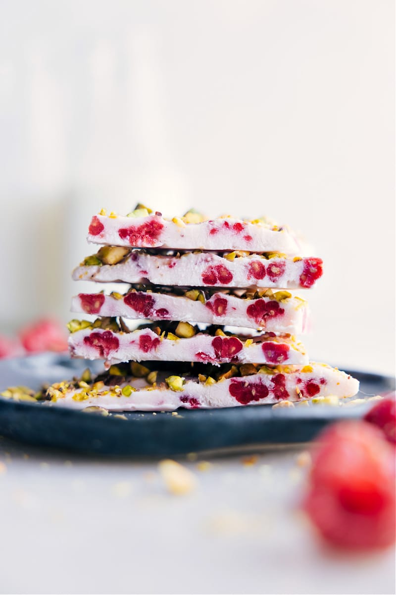 Our favorite Yogurt Bark features a creamy Greek yogurt and raspberry base, adorned with a medley of your favorite crunchy toppings. It's almost unbelievable that a snack this delicious can also be quite good-for-you! Recipe via chelseasmessyapron #snack #quick #easy #simple #healthy #toddlerfriendly #kidsnack #treat #yogurt #bark Image of the treat ready to be enjoyed