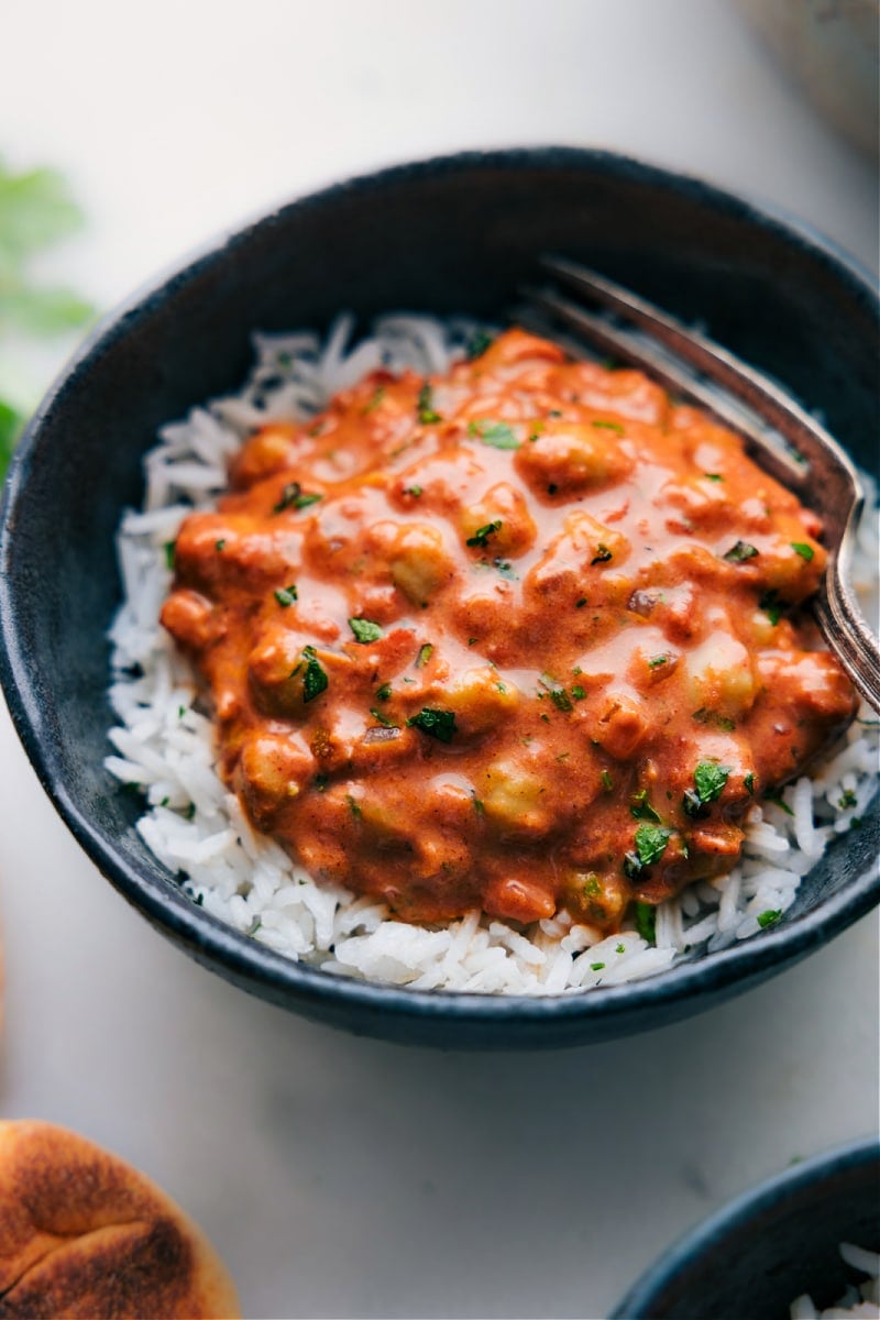 Butter Chickpeas Recipe Butter chicken copycat with garbanzo beans instead of chicken, served over rice in a bowl.
