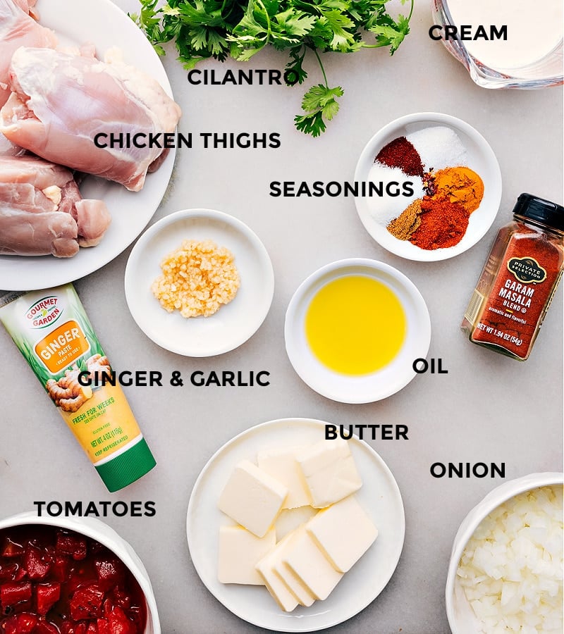 Array of ingredients assembled for the instant pot butter chicken recipe, including spices, chicken, tomatoes, and cream.