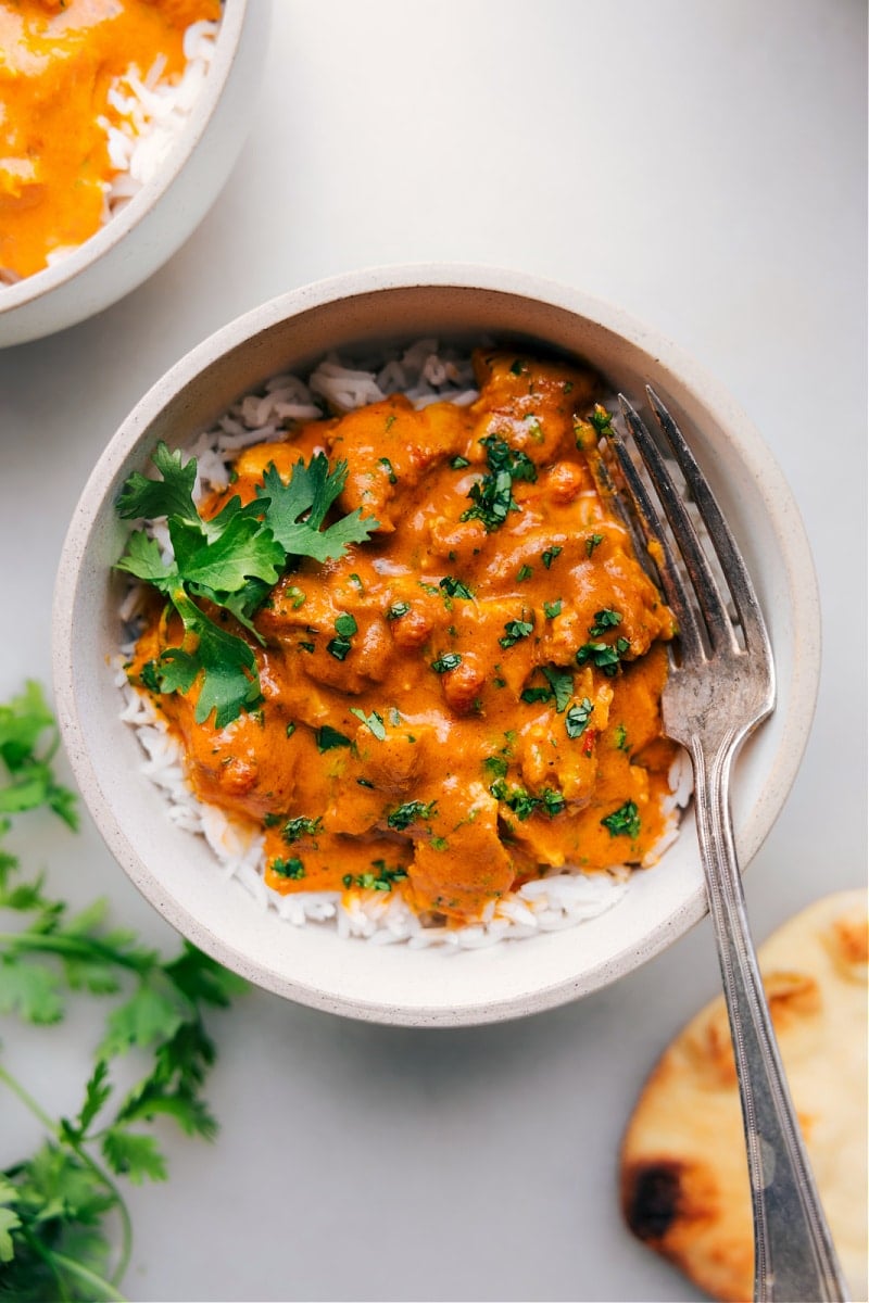 Delicious Instant Pot Butter Chicken over rice with cilantro Bowl of creamy Instant Pot Butter Chicken served over rice, garnished with fresh cilantro.