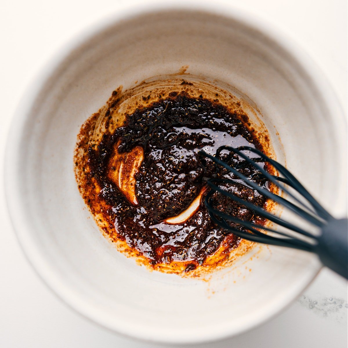 The Best Jerk Chicken Rub Recipe Jerk Chicken marinade ingredients being whisked together in a bowl.